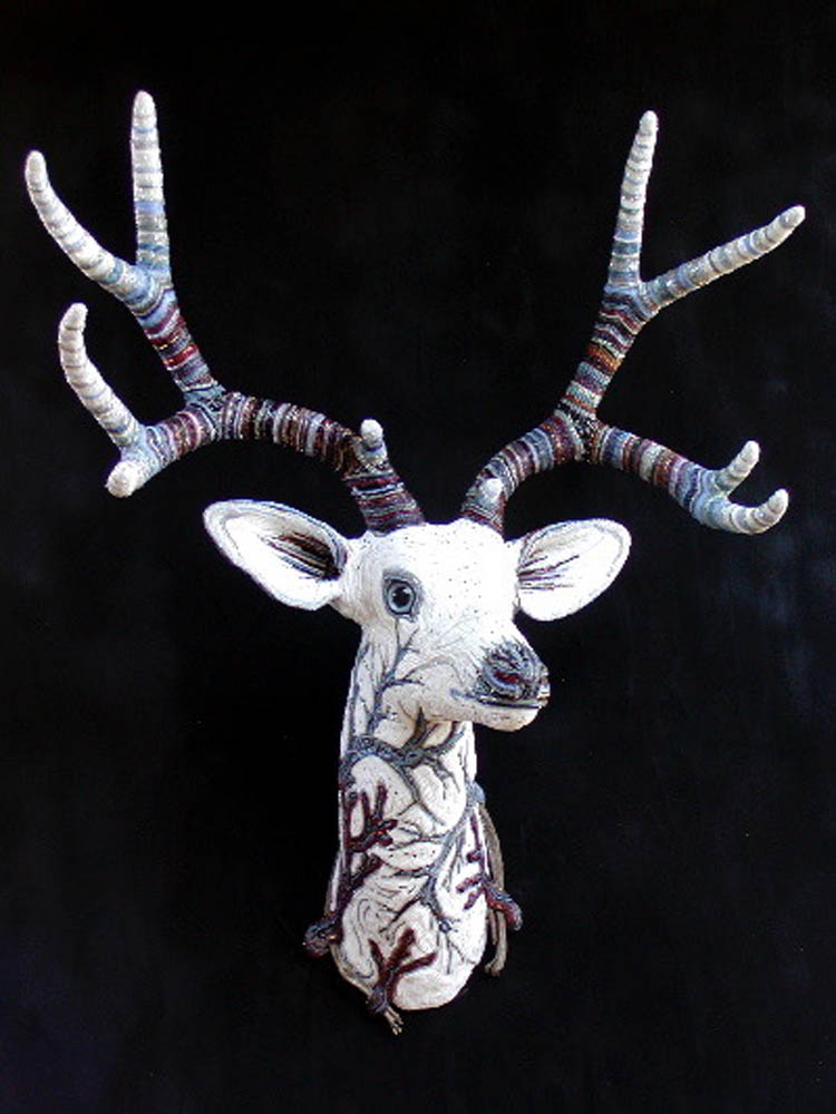 Whitetail deer with beaded antlers, beaded branches on the surface and driftwood.